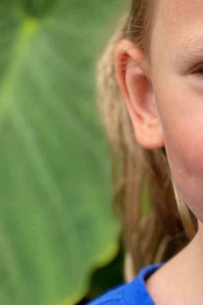 Child drinks from a children’s drink box with a U-shaped paper straw