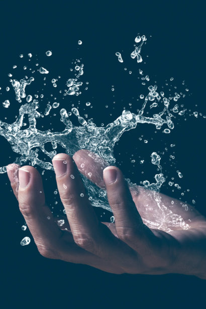 A human hand holding a splash of water.